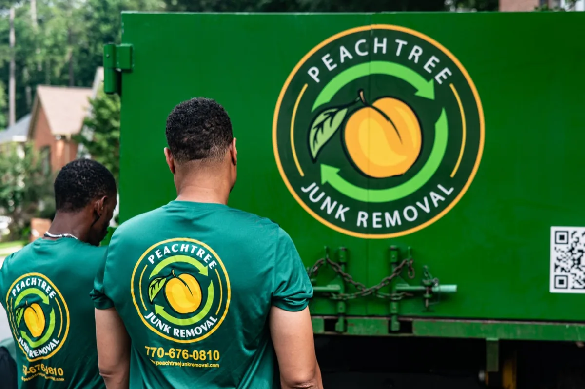 Two uniformed Peachtree crew members at the truck's logo door