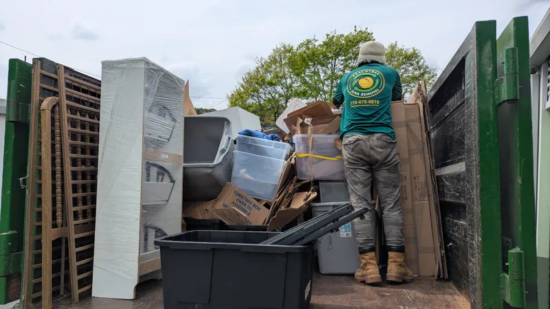 A Peachtree Junk Removal crew member loading a storage unit's contents onto the truck in Atlanta