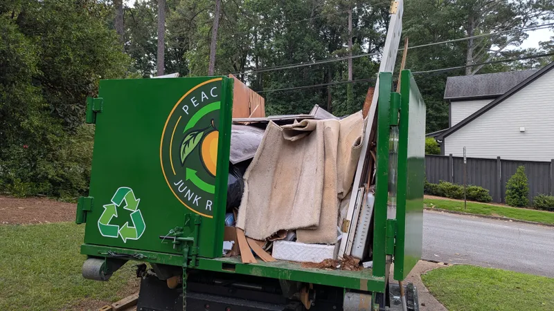 A Peachtree Junk Removal truck loaded with remodeling debris on an Atlanta job